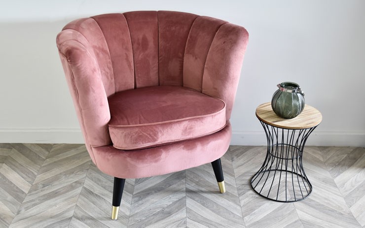 velvet scalloped pink tub chair with small table next to it