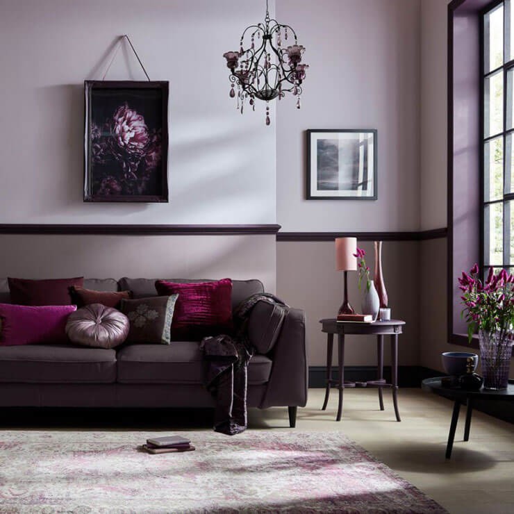 Purple and lavender living room with with a purple couch and light wooden flooring