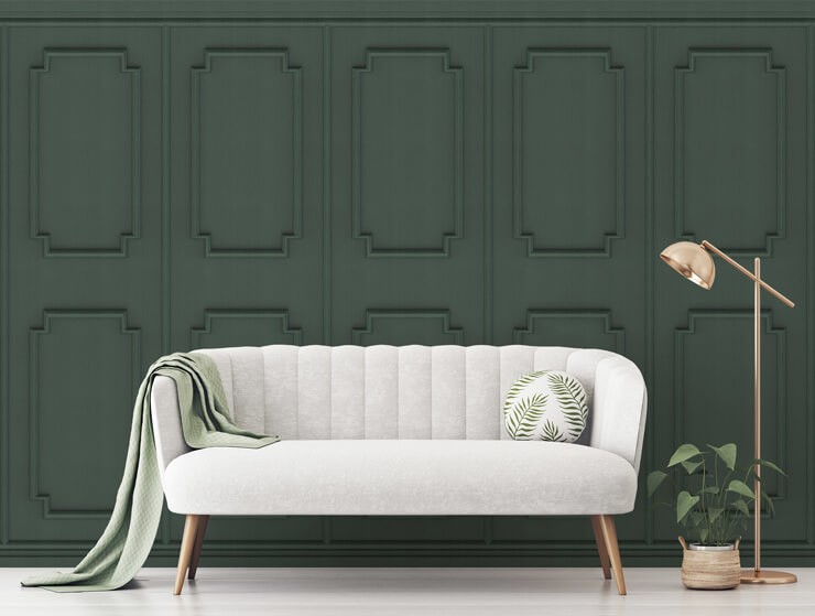 Dark green panelling effect wallpaper with a white couch and gold accessories