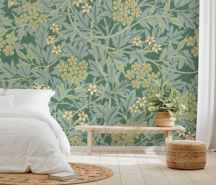Green floral bedroom wall mural with a white bed and wicker rug