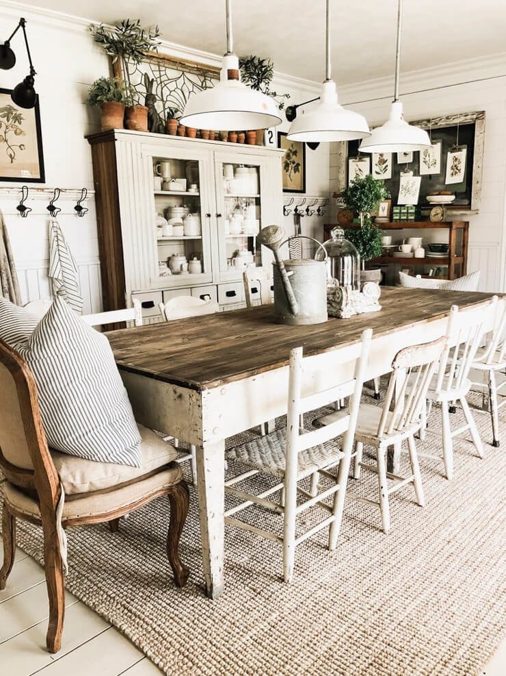Farmhouse dining room inspiration with a large white table and white chairs and a beige rug